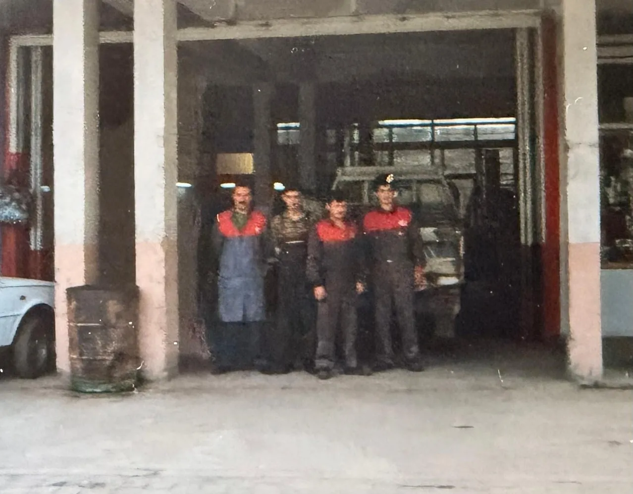 Kia ve İhlas Motor afişli servis girişinin önündeki kişiler.