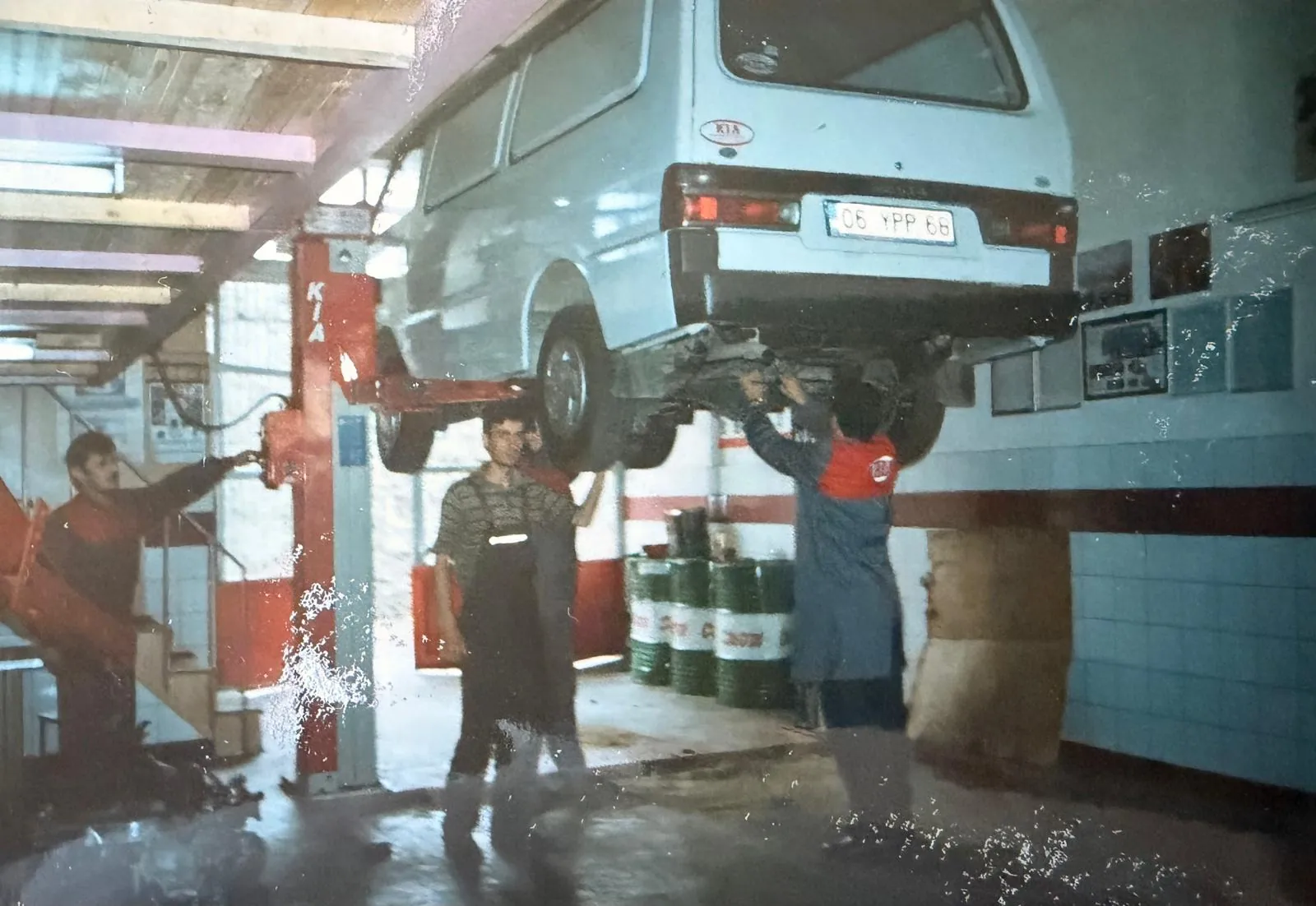 Serviste lift üzerindeki araç ve yanında duran kişiler.