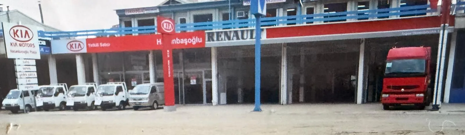 Kia ve Renault tabelalı tesisin önündeki araçlar.